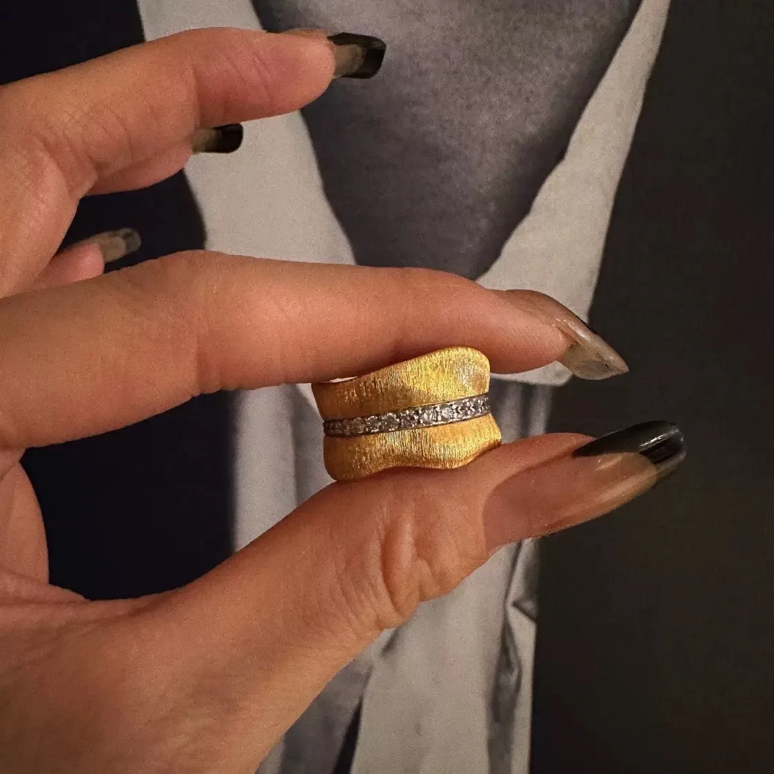 JZ05000 宽版金色戒指手持细节，展示纹理表面及中间透明装饰